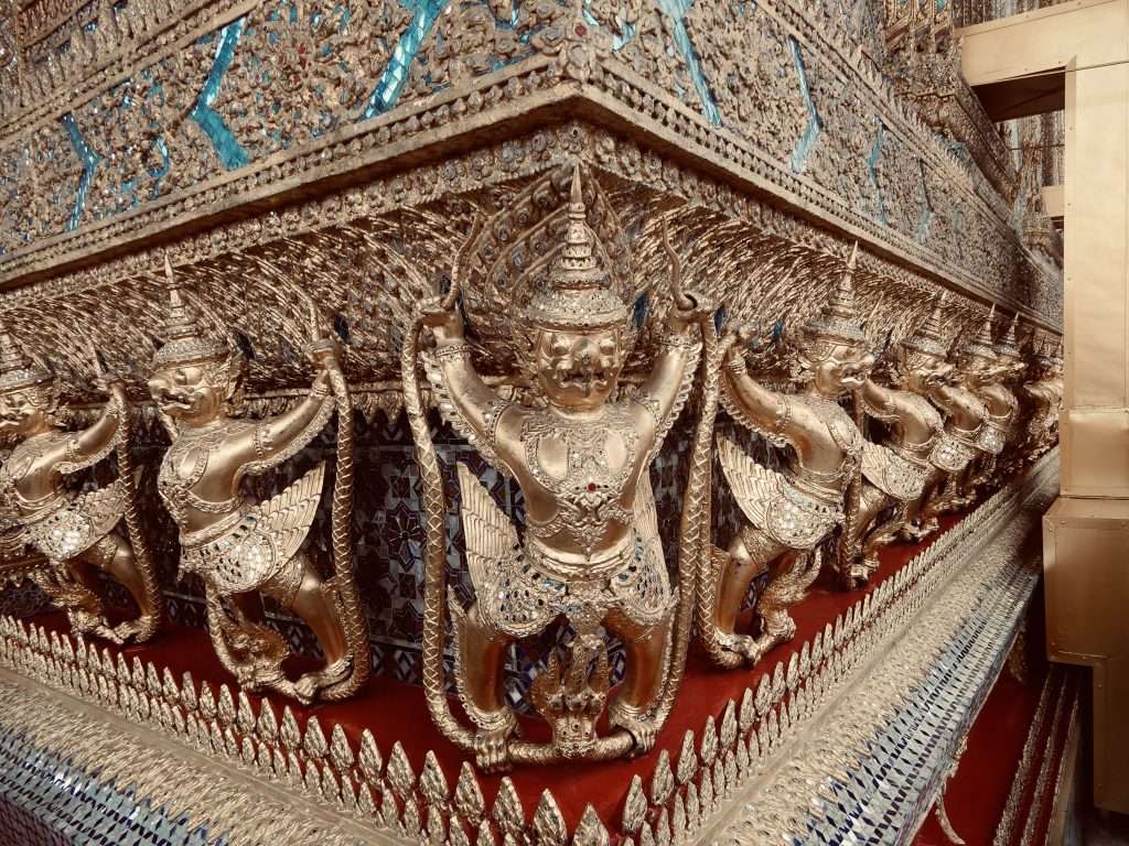 Detailaufnahme goldener Wächterfiguren am Königspalast in Bangkok