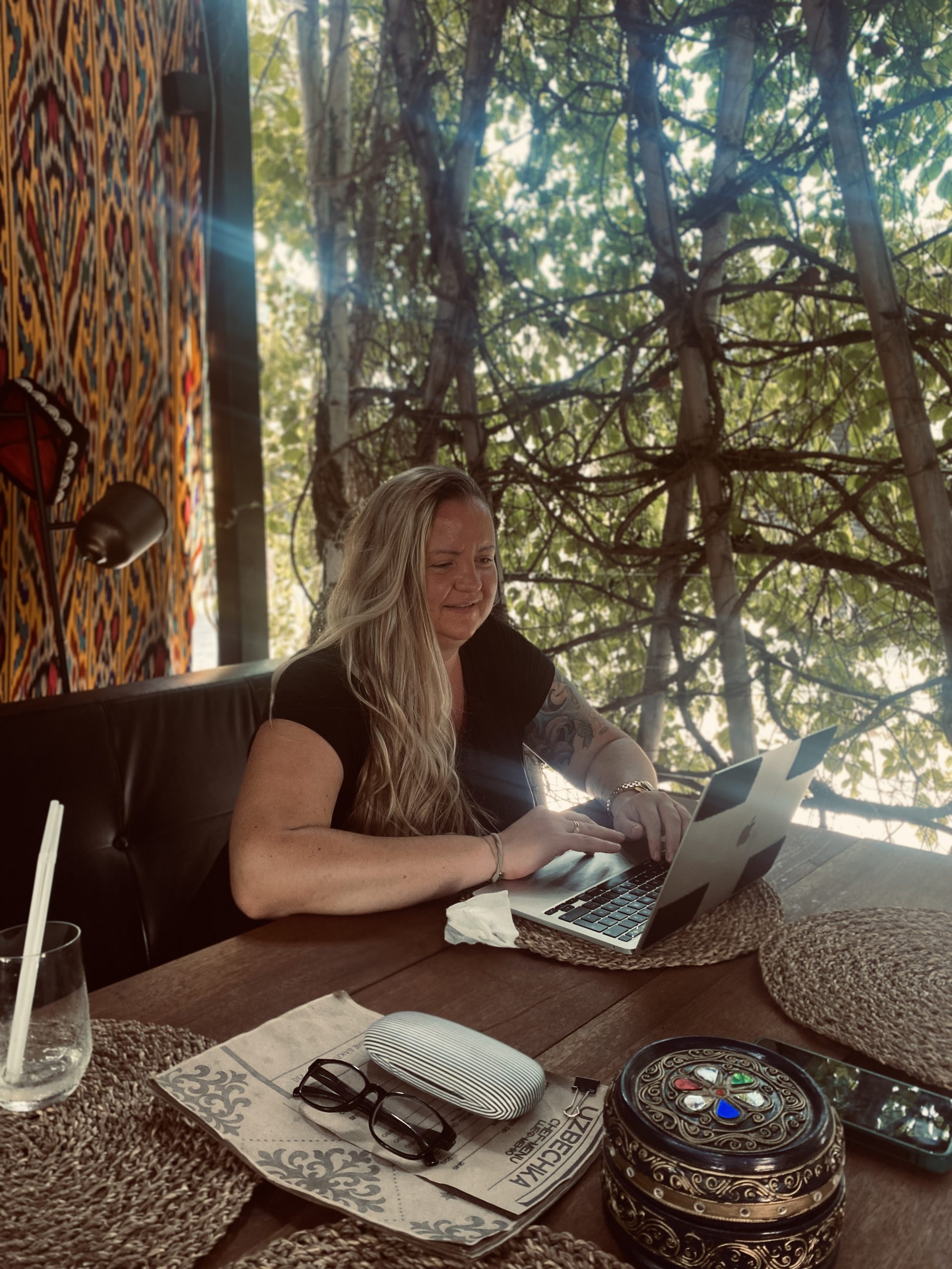 igitales Arbeiten in Thailand – Kreativitaet im Business unterwegs - Bensfar Digitale Positionierung Olga Bensfar arbeitet mit Laptop in einem Café in Thailand unter Bäumen – digitales Arbeiten im Ausland. Kreativitaet im Business