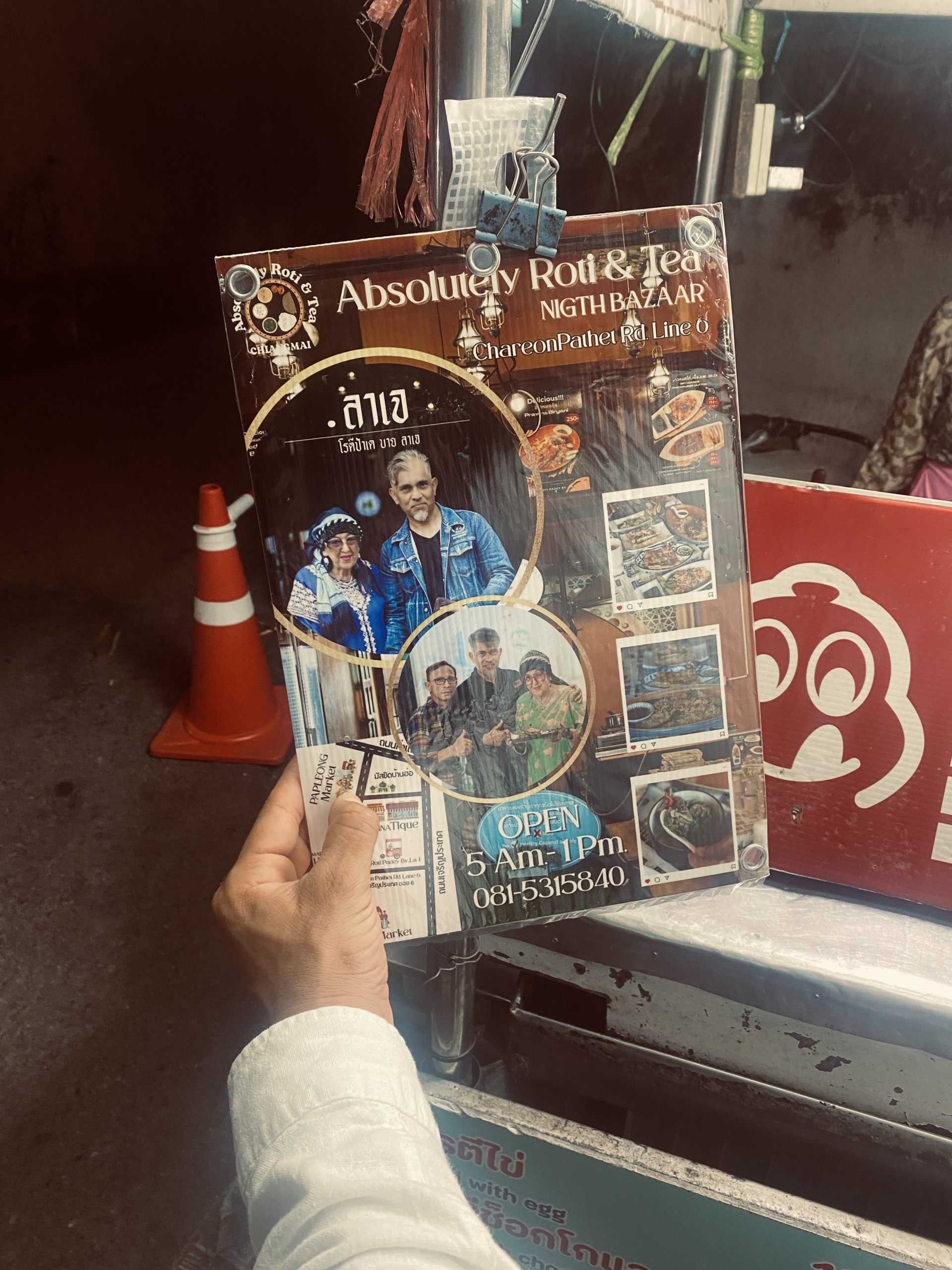 Online Marketing lernen. Werbetafel eines Streetfood-Stands mit Roti & Tea auf dem Night Bazaar in Chiang Mai, Thailand, mit Fotos der Betreiber und Öffnungszeiten.